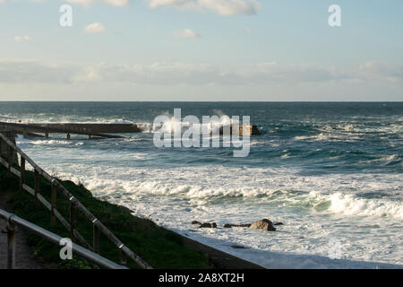 Onde di oltre una parete del porto in autunno mari pesanti Foto Stock