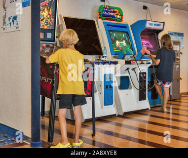 Mar Mediterraneo - Luglio 23, 2019: un ragazzo e una ragazza giochi gioco di combattimento su bambini's arcade slot machine sul traghetto Moby nave passeggeri. Foto Stock