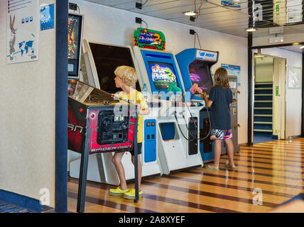 Mar Mediterraneo - Luglio 23, 2019: un ragazzo e una ragazza giochi gioco di combattimento su bambini's arcade slot machine sul traghetto Moby nave passeggeri. Foto Stock