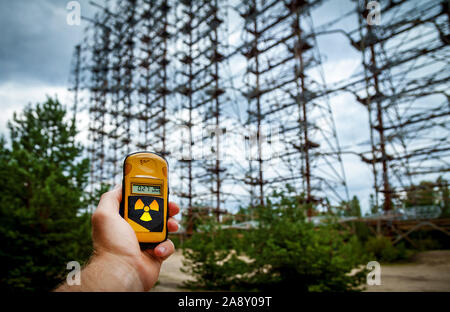 Il dosimetro in mani con un livello di radioattività a 0,27 radiazione gamma, l'ex militare di sistema radar Duga in Chernobyl Zona di esclusione, Ukrai Foto Stock