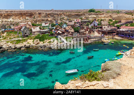 Vista del famoso villaggio di Popeye con coloratissime case di legno e il golfo di Malta. Foto Stock