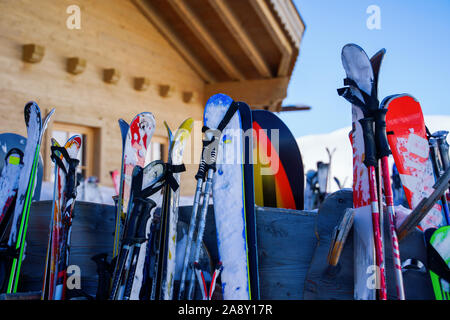 Immagine di multi-colore di sci e snowboard nella neve in inverno resort nel pomeriggio. Sfondo sfocato. Foto Stock