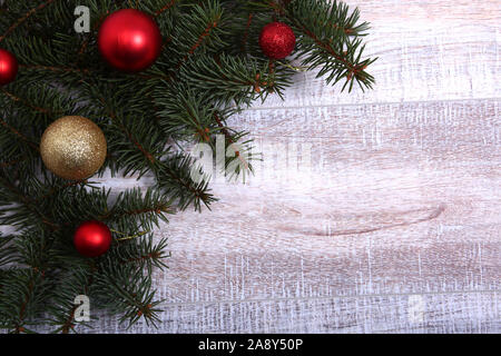 Natale o Capodanno background: pelliccia-tree, rami, vetro colorato sfere , decorazione e coni su uno sfondo di legno Foto Stock