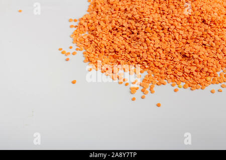 Materie di lenticchie rosse sparse su sfondo bianco Foto Stock