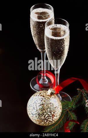 Natale e Capodanno celebrazione concetto: due calici di champagne drink e una bottiglia di champagne su un tavolo con le decorazioni di Natale. Foto Stock