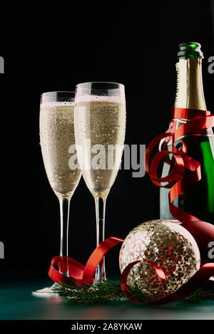 Natale e Capodanno celebrazione concetto: due calici di champagne drink e una bottiglia di champagne su un tavolo con le decorazioni di Natale. Foto Stock