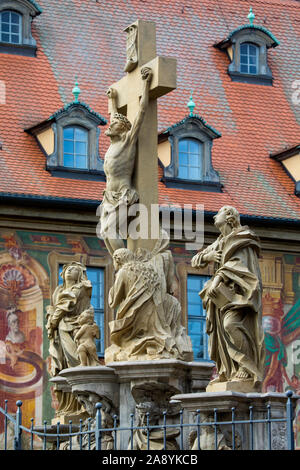 Il Kreuzigungsgruppe, o gruppo della crocifissione, la statua si trova su Obere Brucke con Altes Rathaus dietro, nella città bavarese di Bamberg in Germania. Foto Stock