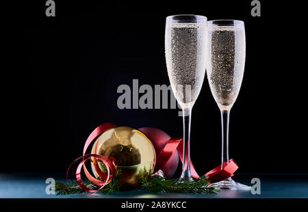 Natale e Capodanno celebrazione concetto: due calici di champagne drink e una bottiglia di champagne su un tavolo con le decorazioni di Natale. Foto Stock