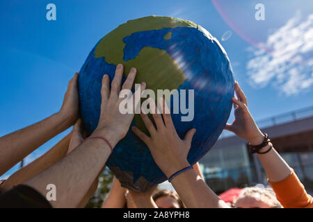 Chiusura del gruppo di mani di contenimento e protezione di terra globo con razzi lente. Expresion attivista a protestare in San Girolamo Foto Stock