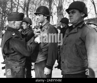 Soldati stand in righe all attenzione all'esterno. La neve copre il terreno. Il colonnello Wilson perni del cluster sulla medaglia di Sgt. Driscoll. Foto Stock