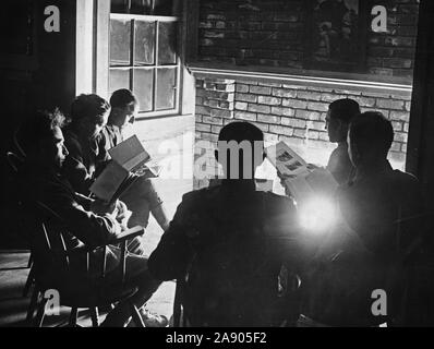 3/11/1918 - intorno al caminetto nel campo Library. L esercito nazionale lettura gli uomini intorno al caminetto in American Library Association a Camp Upton. Foto Stock