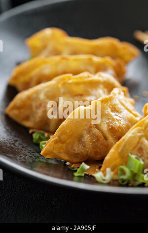 Potstickers fritti o gnocchi su una piastra nera Foto Stock