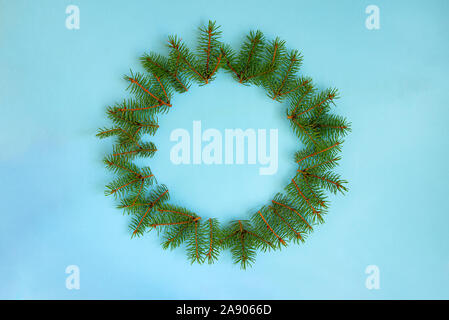 Una ghirlanda di pino rami su sfondo blu. Foto Stock