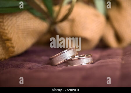 Bella tonica foto con gli anelli di nozze giacciono su una superficie contro lo sfondo Foto Stock