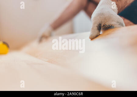 Il master abilmente installa Parquet - pavimento galleggiante - piano lavoro durante la finitura Foto Stock