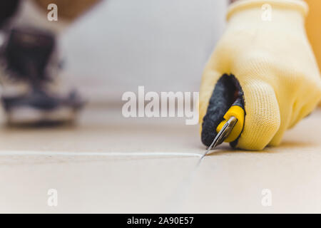 Come la saldatura a caldo pavimento in vinile con pistola termica - quarto di luna spatola Coltello per zoccoli con lama a pavimento in vinile - saldatura saldatura a caldo di installazione di vinile Foto Stock