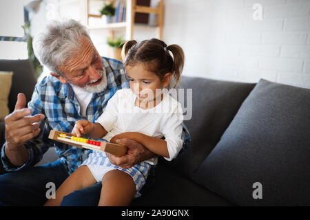 Carino bambina gioca con il suo nonno a casa. Happy family concept Foto Stock