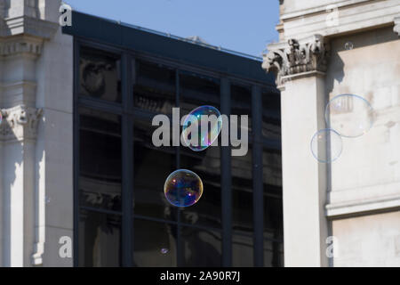 Le bolle create da un suonatore ambulante / street performer , di fronte alla National Gallery, Trafalgar Square, London, Regno Unito Foto Stock