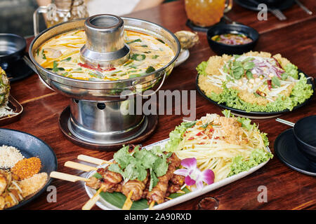 Zuppa di calamari, spiedini di pollo e fritte gamberetti sul ristorante in legno tabella Foto Stock