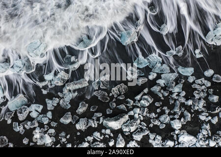 Vista aerea del ghiaccio e floes iceberg sulla spiaggia di diamante durante il tramonto. L'inizio della primavera in Islanda Foto Stock