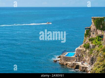 Vista drone di edifici in armonia con la ripida cliffside sulla Costiera Amalfitana, una località turistica di destinazione. Foto Stock
