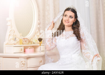 Giovane bella sposa in abito bianco in posa Foto Stock