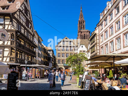 Turisti che si godono il patrimonio medievale e caffetterie lungo la strada nel quartiere storico di Strasburgo, Francia, a pochi passi dalla cattedrale di Notre Dame. Foto Stock