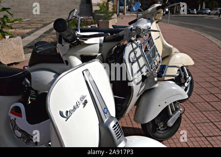 Gruppo di vecchio stile scooter " Vespa " parcheggiato sulla strada Foto Stock