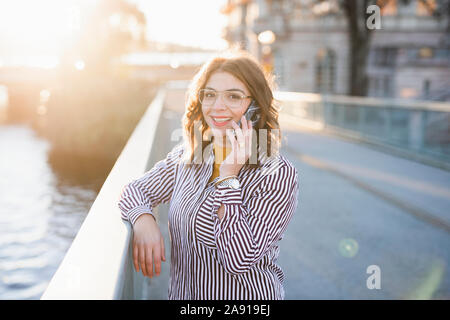 Donna sorridente al telefono Foto Stock