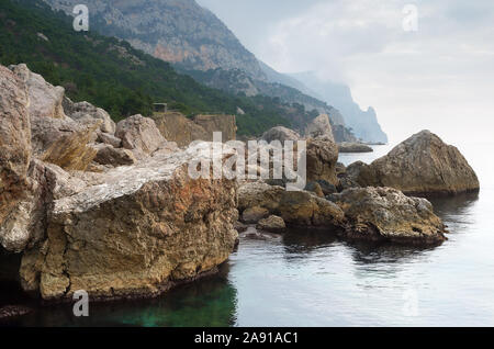 Seascape giorno nuvoloso. Spiaggia con rocce e sassi. Crimea Foto Stock