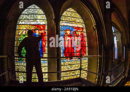 Vetro testa conservatore Sam Kelly ispeziona i Angeli Laudantes e Angeli Ministrantes vetrate a Cattedrale di Salisbury come lavori di restauro per pulire, conservare e ripristinare le finestre, installato nel 1879, ottiene in corso. Foto Stock