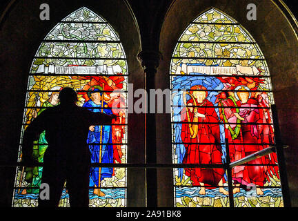 Vetro testa conservatore Sam Kelly ispeziona i Angeli Laudantes e Angeli Ministrantes vetrate a Cattedrale di Salisbury come lavori di restauro per pulire, conservare e ripristinare le finestre, installato nel 1879, ottiene in corso. Foto Stock