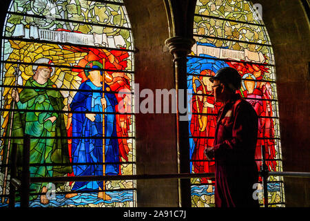 Vetro testa conservatore Sam Kelly ispeziona i Angeli Laudantes e Angeli Ministrantes vetrate a Cattedrale di Salisbury come lavori di restauro per pulire, conservare e ripristinare le finestre, installato nel 1879, ottiene in corso. Foto Stock