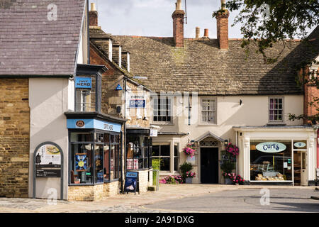 Cafe Nero e nei piccoli negozi di pittoreschi edifici antichi. Market Place, Oakham, Rutland, Inghilterra, Regno Unito, Gran Bretagna Foto Stock