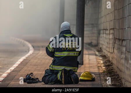 Sderot, Israele. Xii Nov, 2019. Un vigile del fuoco israeliano presso il sito di una fabbrica di masterizzazione a seguito di un colpo diretto da un razzo lanciato dalla striscia di Gaza. Due senior Jihad islamica leader sono stati mirati in incursioni aeree israeliane nella striscia di Gaza e Siria il Martedì, innescando una delle peggiori turni di violenza nella regione in cinque anni. Credito: Ilia Yefimovich/dpa/Alamy Live News Foto Stock