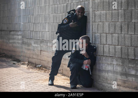 Sderot, Israele. Xii Nov, 2019. Due poliziotti israeliani prendere la copertura come un razzo sirena di allarme si spegne. Due senior Jihad islamica leader sono stati mirati in incursioni aeree israeliane nella striscia di Gaza e Siria il Martedì, innescando una delle peggiori turni di violenza nella regione in cinque anni. Credito: Ilia Yefimovich/dpa/Alamy Live News Foto Stock