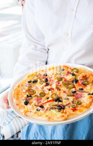 Una pizza messicana con il peperoncino piccante di persona le mani Foto Stock