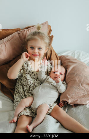 Ragazza con i gemelli neonati sul letto Foto Stock