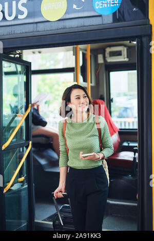Viaggiatori femmina andando fuori il bus terminal Foto Stock