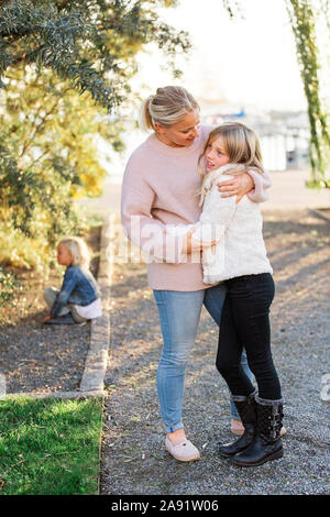 La madre abbraccia la figlia Foto Stock