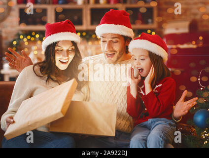 Sorpreso di apertura della famiglia regali di Natale insieme in cucina festiva Foto Stock