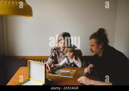 Nonni e nipote facendo puzzle Foto Stock