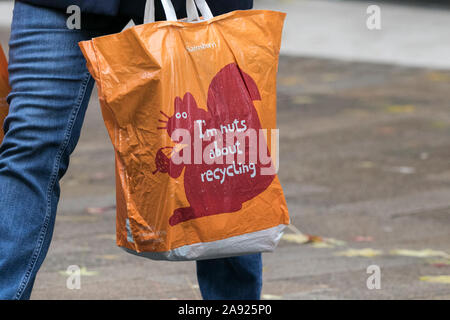 Sainsburys; ì dadi sul riciclaggio; 100% arancione in plastica riciclata riutilizzabili sacchetti del supermercato per la vita Foto Stock