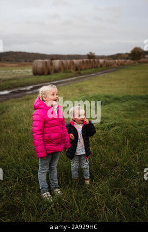 Due bambini tenendo le mani su di un campo Foto Stock
