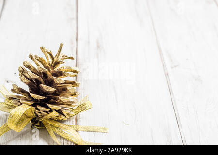 Cono di pino come ornamento di Natale su sfondo di legno Foto Stock