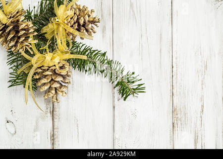 Bianco sullo sfondo di legno con decorazione di Natale, pigne appeso sul ramo dell albero di natale Foto Stock