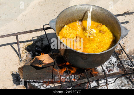 La cottura pilaf in un calderone sul fuoco aperto a picnic. National cibo asiatico. Uzbek pilaf. Foto Stock