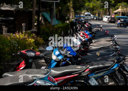 KRABI, Tailandia - 10 luglio 2019. Affollati parcheggio posto in Krabi con piena di motociclette. Un sacco di moto parcheggio nelle righe sul marciapiede in Foto Stock