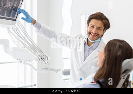 Bello il dentista per spiegare il suo paziente x-ray risultati Foto Stock