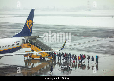 I passeggeri in coda all'aperto a bordo degli aerei in caso di maltempo Foto Stock